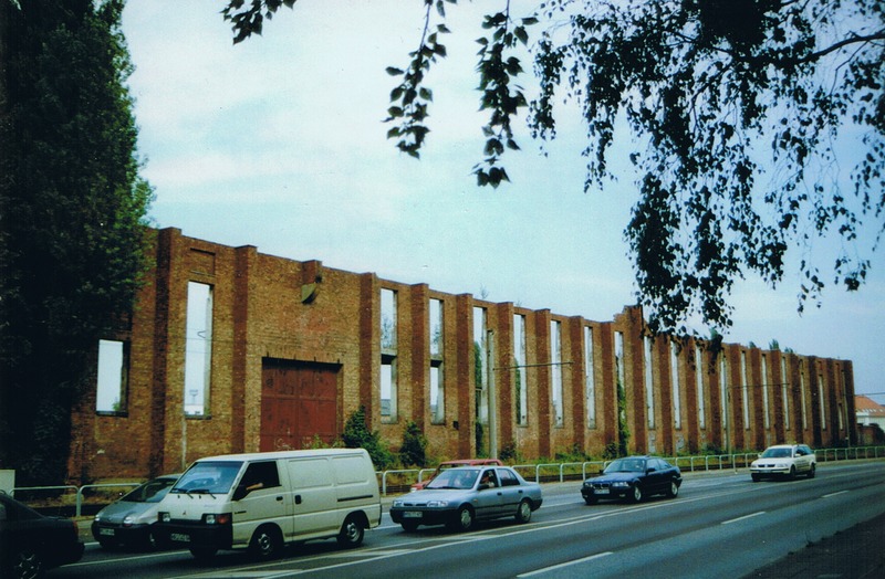 Heinkelmauer, Rostock, Lübecker Straße (2002). Die Wand gehörte ursprünglich zu einem Gebäude, das in den 1930er Jahren von der Firma Heinkel genutzt wurde. Später wurde der Bau vom VEB Schiffswerft Neptun Rostock genutzt. Neben Schiffen baute die Werft als Konsumgüter auch Kühlschränke. Die Neptun-Werft beschäftigte Mitte der achtziger Jahre 6500 Menschen. Heute wird der Betrieb an anderer Stelle in Rostock fortgeführt.