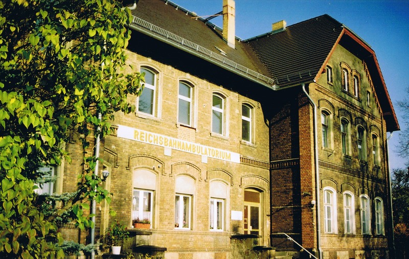 Hoyerswerda, Bahnhofsallee (2005). Ursprünglich als Wohnhaus für Reichsbahnmitarbeiter genutzt, wurde das Gebäude in den 1980er Jahren zum Reichsbahn-Ambulatorium umfunktioniert. Anstelle des heutigen Schriftzuges befand sich früher ein breiter Balkon, der 1983 entfernt wurde.