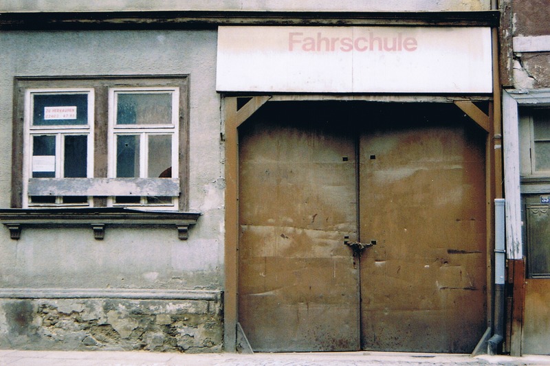 Mühlhausen, Erfurter Straße  (2004). Das Gebäude entstand im Jahre 1862. Ab 1958 Jahre nutzte es die PGH Einheit Mühlhausen, ein Klempner-, Heizungs- und Installationsbetrieb. Nach dem sich die Produktionsgenossenschaft zur volkseigenen Technischen Gebäudeausrüstung wandeln musste, verblieben hier noch bis in die 1970er Jahre das Lager und die Lehrwerkstatt. Die Fahrschule wurde von 1992 bis 1995 betrieben.